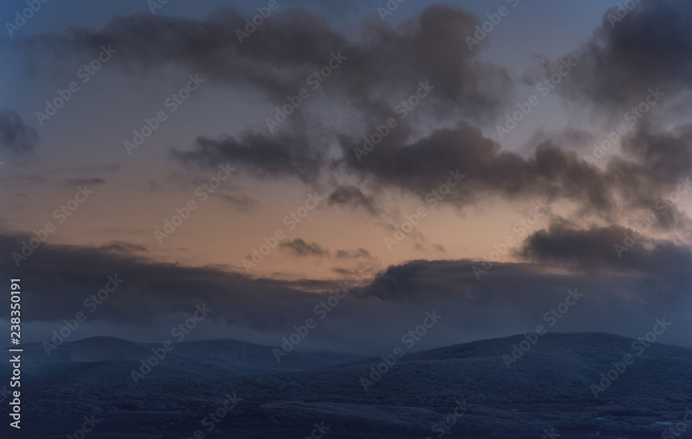 Winter cloudy sunset in snow Agarmysh mountains