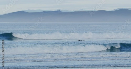 Slow motion of surfers in Morro Bay, Claifornia photo