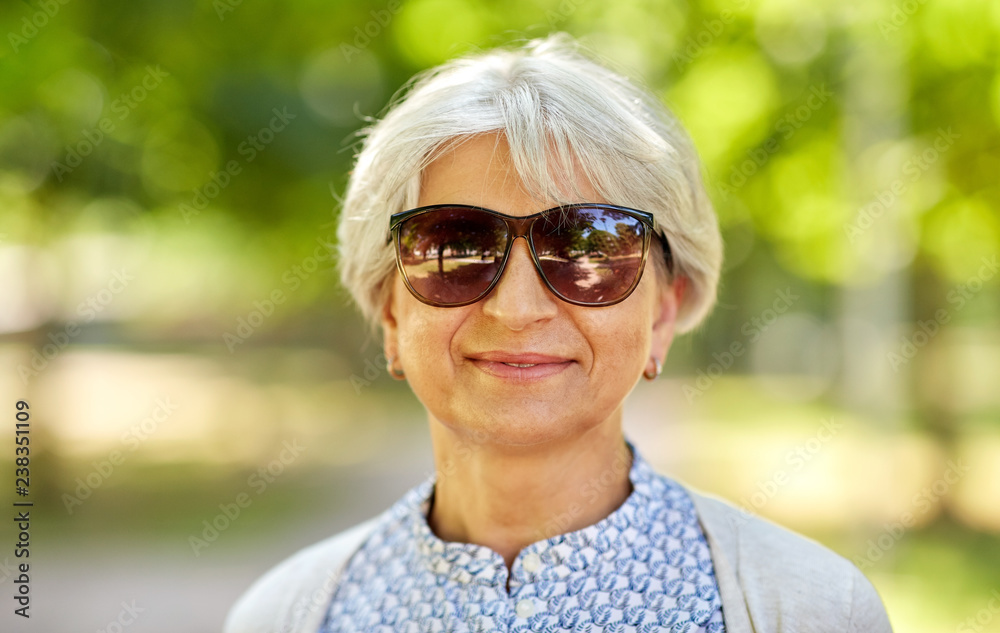old age, eyewear and people concept - portrait of happy senior woman in sunglasses at summer park old age, eyewear and people concept - portrait of happy senior woman in sunglasses at summer park