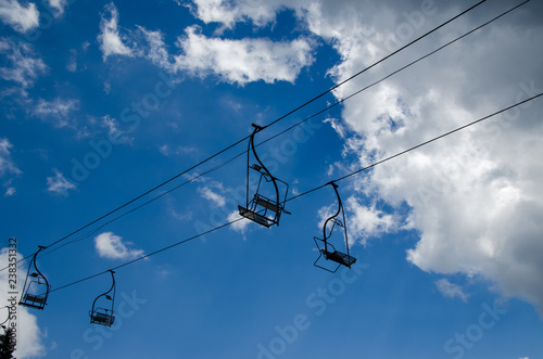 Ski lift chairs with no one on them - against cloudy sky
