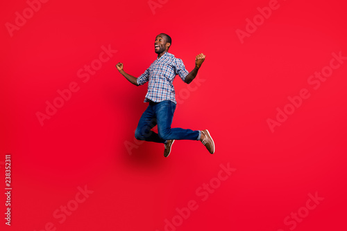 Full length body size portrait of nice funny handsome cheerful positive guy wearing checkered shirt showing winning gesture party in air isolated on bright vivid shine red background