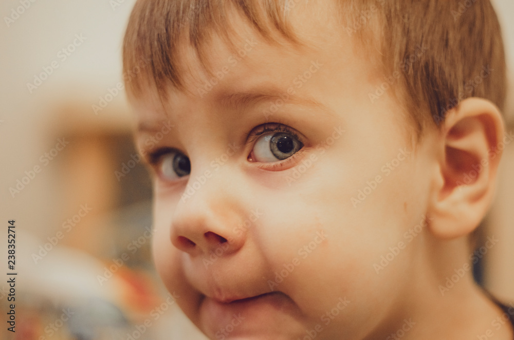 Portrait of happy child toddler boy smiling close up on backgraund of his room or in the kitchen