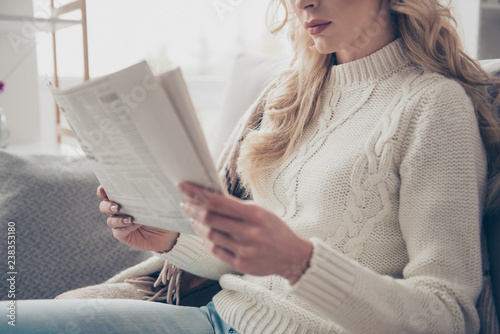 Cropped profile side view portrait of nice lovely attractive wavy-haired lady housewife wearing sweater holding in hands reading digest in light interior room photo