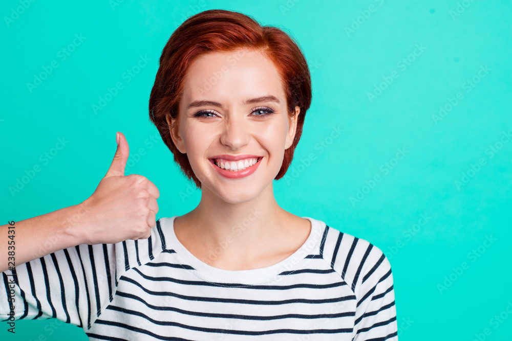 Close-up portrait of her she nice cool charming attractive cheerful positive red-haired lady wearing striped pullover showing thumbup isolated over bright vivid shine green turquoise background