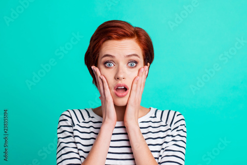 Close-up portrait of nice charming attractive lovely pretty shocked red-haired lady in striped pullover palms on cheeks isolated over bright vivid shine green turquoise background