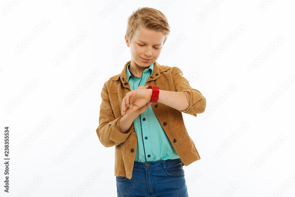 Joyful positive nice boy checking the time Joyful positive nice boy checking the time