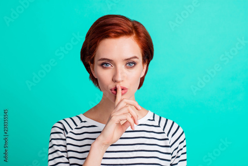Close-up portrait of nice attractive sweet lovely red-haired lady in striped pullover showing hush sign symbol isolated over bright vivid shine green turquoise background photo