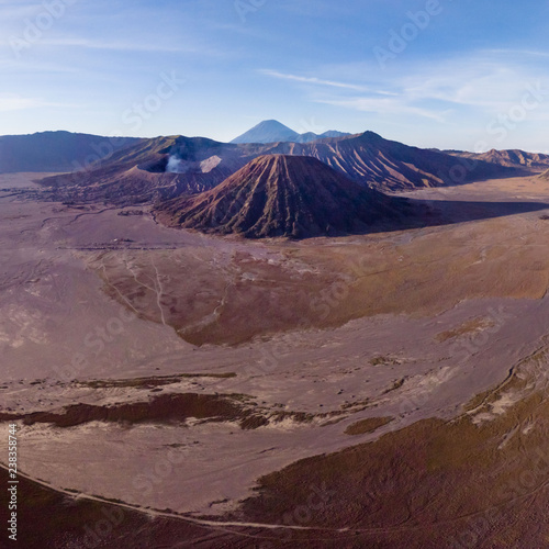 Mount Bromo volcano crater erupts in the caldera, behind Gunung Batok, with Gunung Semeru in the background, Java, Indonesia.