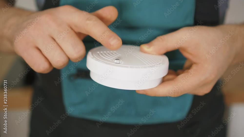 Man testing smoke detector before use.