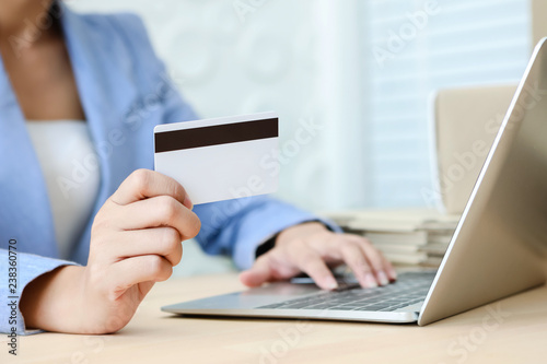 Hand holding credit card typing on the keyboard of laptop for online shopping ecommerce concept