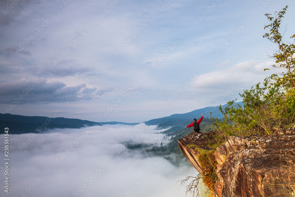Fototapeta premium The man are looking to the sea of mist on high mountain in Nakornchoom, Phitsanulok province, Thailand.