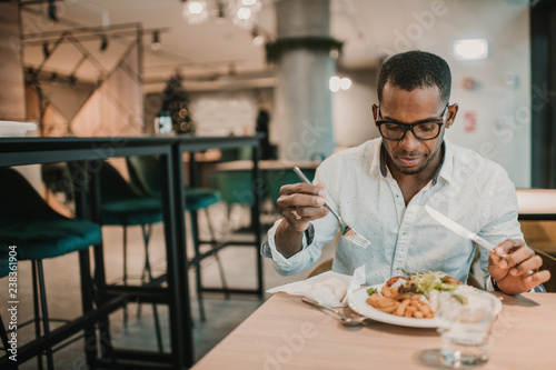 Black man eating in restaurant photo