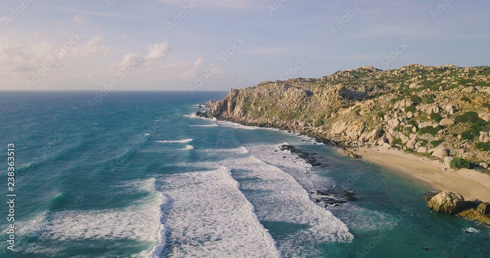 Aerial view of beautiful tropical desert island beach from drone. Stock image of landscape paradise tropical island beach with blue color ocean water, wave, sea surface. Top view and amazing nature