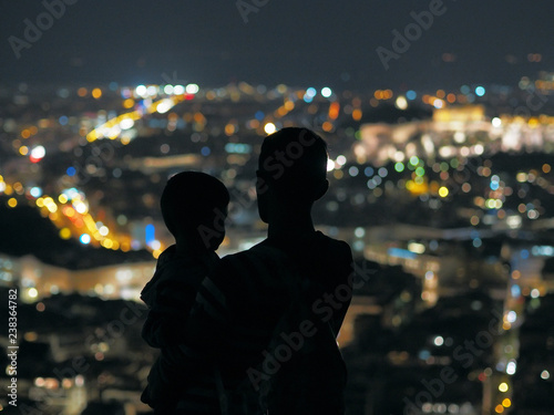 Father and son looking at the night city.