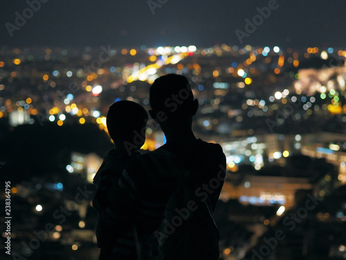 Father and son looking at the night city.