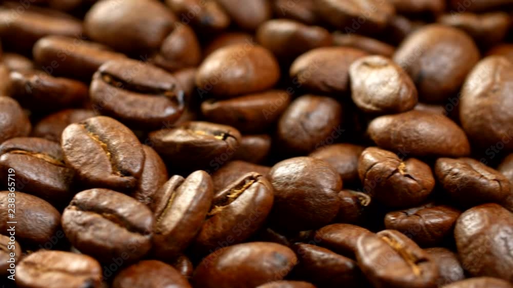 Coffee beans background. Close-up of a rotating panel, filled with brown roasted appetizing coffee beans. 4K Coffee beans background. Close-up of a rotating panel, filled with brown roasted appetizing coffee beans. 4K
