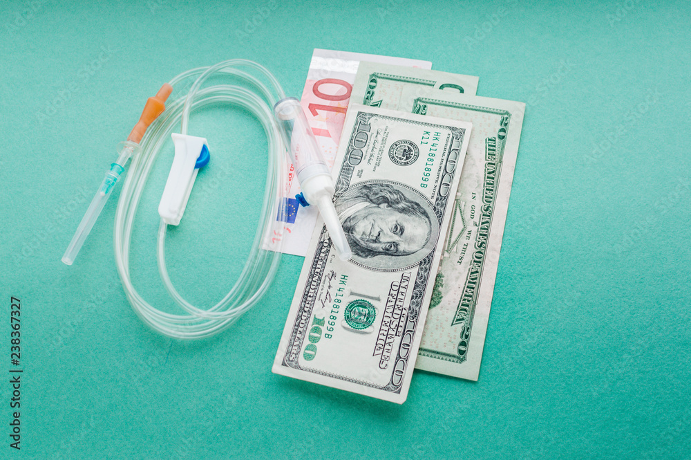 American dollars and euros with a dropper. Concept expensive cancer treatment American dollars and euros with a dropper. Concept expensive cancer treatment