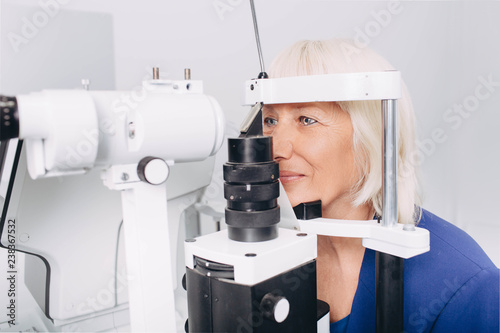 Fototapeta Naklejka Na Ścianę i Meble -  Senior woman checking vision with special eye equipment at doctor office