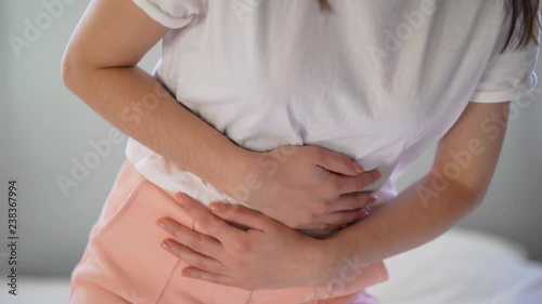 Wallpaper Mural Young woman suffering from abdominal pain while sitting on bed at home Torontodigital.ca