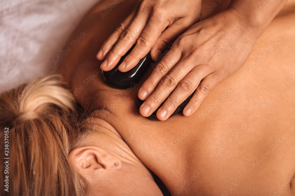 Top view of a hot stone on female back Top view of a hot stone on female back
