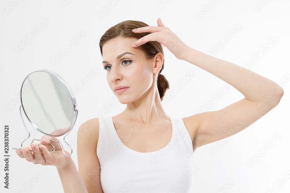 Smiling young woman with white teeth looking in mirror isolated on white background. Skin care and anti aging concept. Beauty and body health. Copy space Smiling young woman with white teeth looking in mirror isolated on white background. Skin care and anti aging concept. Beauty and body health. Copy space