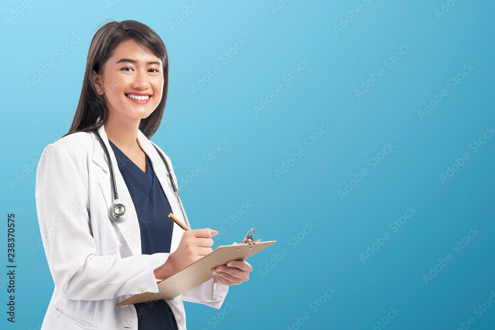 Pretty asian doctor woman with lab coat writing notes on the clipboard Pretty asian doctor woman with lab coat writing notes on the clipboard