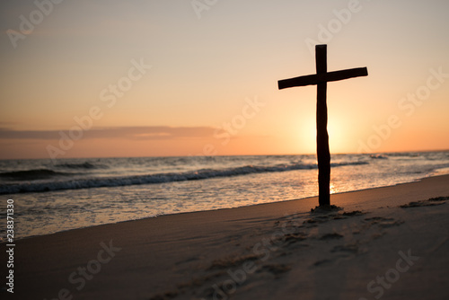 A Christian holy cross standing on the horizon of light and sea