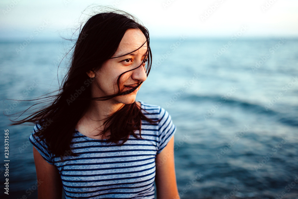 Portrait of a young woman with closed eyes and hair on her face at the sand sea beach Portrait of a young woman with closed eyes and hair on her face at the sand sea beach