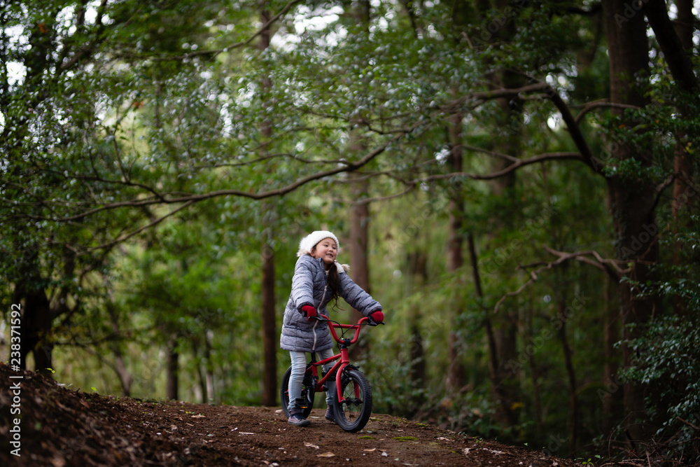 森の中で自転車に乗る女の子