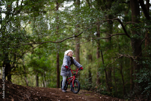 森の中で自転車に乗る女の子 © hakase420
