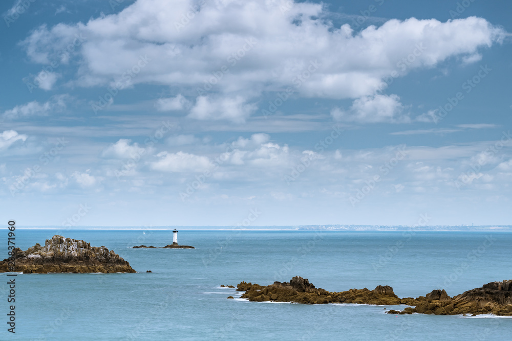 Lighthouse and rocks of Pointe du Grouin on a cloudy day in summer