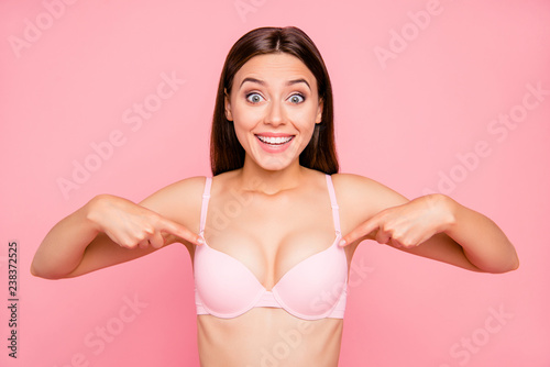 Close up portrait of attractive beautiful delighted gorgeous skinny her she girl showing nice proportions of decollete cleavage in push up bra isolated on pink background photo