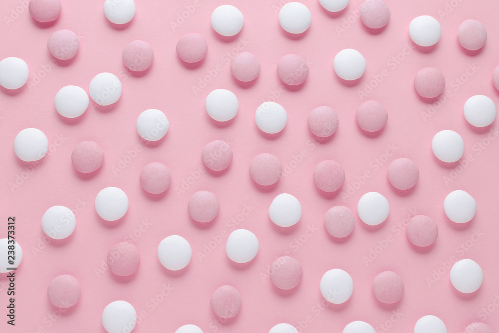 pink and white candy or pills on pastel color background, abstract pattern pink and white candy or pills on pastel color background, abstract pattern