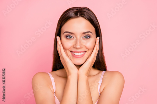 Close-up portrait of nice lovely adorable attractive winsome fascinating cheerful positive girl in beige bra touching cheeks isolated over pink pastel background