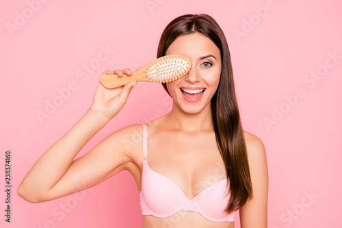 Close-up portrait of nice lovely charming attractive cheerful funky girl in beige bra with healthy strong straight shiny hair covering closing one eye comb opened mouth isolated over pink background