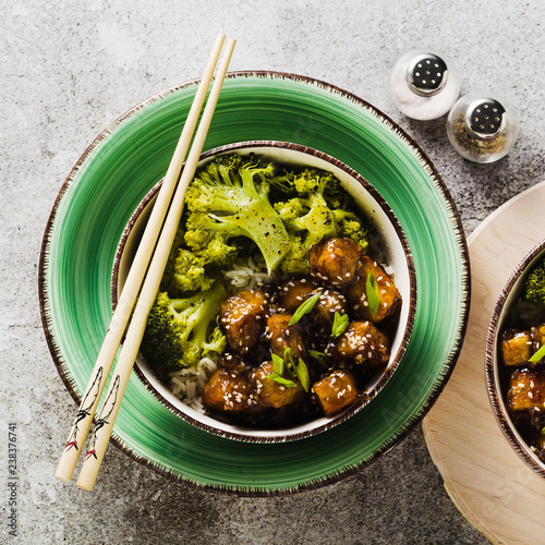 Basmati rice with tofu in General Tso sauce and steamed broccoli. full healthy vegetarian lunch or dinner on a stone table photo