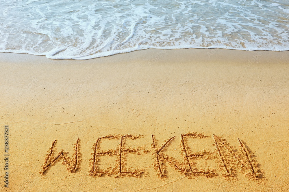 Fototapeta premium The word concept, WEEKEN handwriting on sand beach.