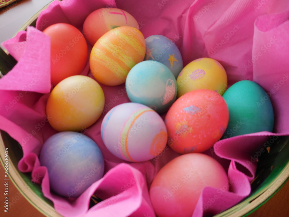 Colored Easter eggs in pink basket from above Colored Easter eggs in pink basket from above