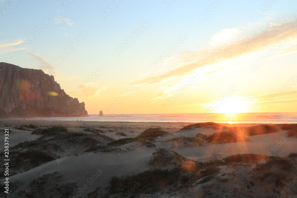 Sunset, sand dunes and the ancient volcanic plug Morro rock in Morro Bay California 