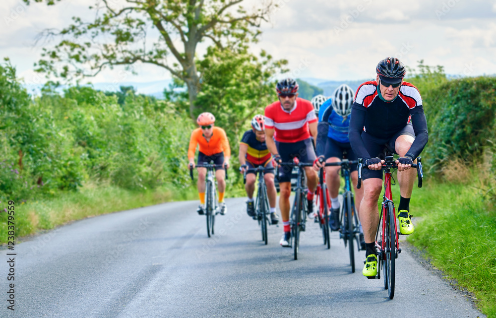 A group of cyclists on a bike race on a sunny day along country roads in the UK. A group of cyclists on a bike race on a sunny day along country roads in the UK.