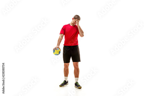 The sad fit caucasian young male handball player at studio on white background. Human emotions concept