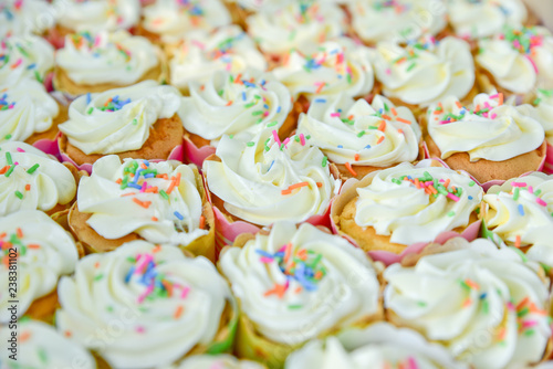 Colorful cupcakes in a box, vanilla cupcakes with pink and white cream, selective focus, close up