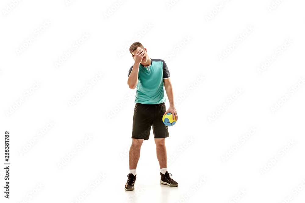The sad fit caucasian young male handball player at studio on white background. Human emotions concept The sad fit caucasian young male handball player at studio on white background. Human emotions concept