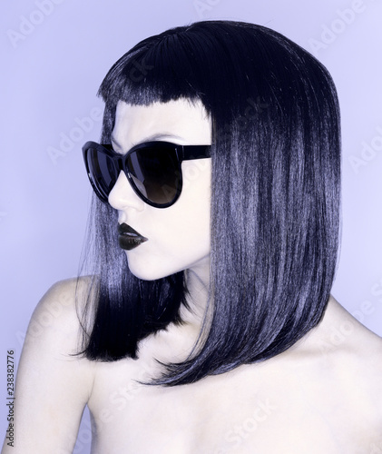 naked woman with blacks hair short fringe and sunglasses on a colored background
