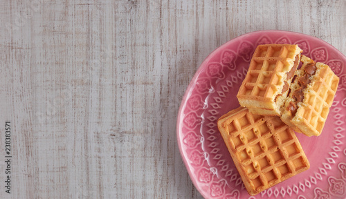 Top view sweet fresh Viennese waffles on plate isolated on wooden table. copy space. European for breakfast.