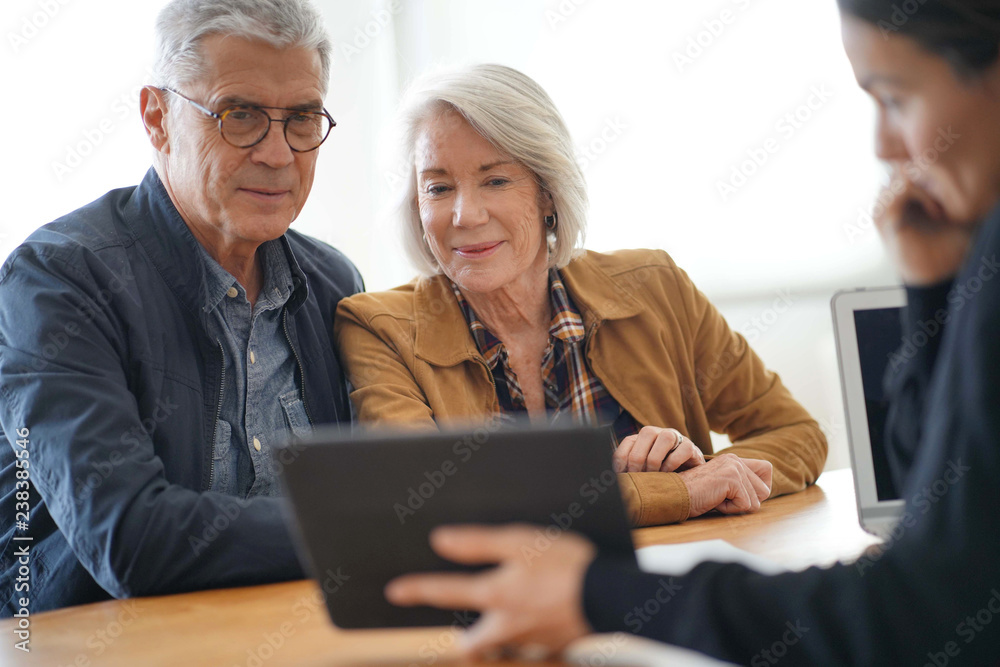 Fototapeta Modern senior couple going through remodelling ideas on tablet