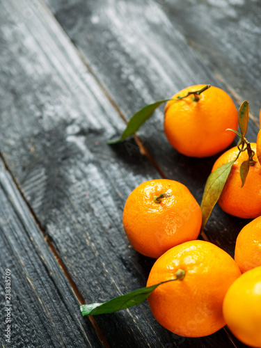 Pile of ripe juicy orange tangerines on a wooden table with copy space