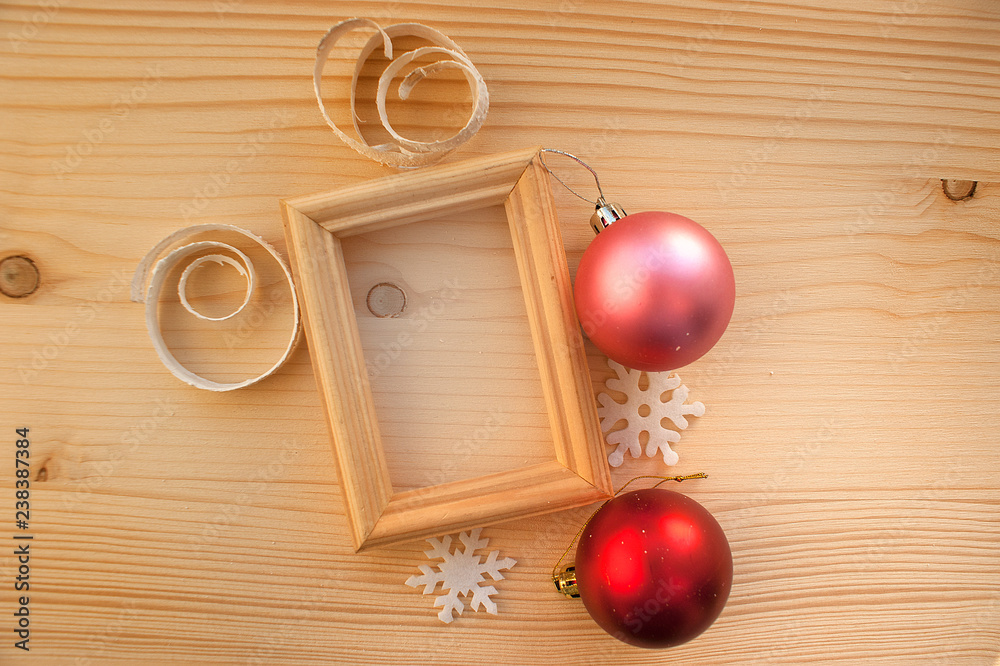 Wooden photoframe of gold color on a wooden background. Christmas decorations - balls, snowflakes. Background for congratulations on Christmas and New Year. Photo album page template. Wooden photoframe of gold color on a wooden background. Christmas decorations - balls, snowflakes. Background for congratulations on Christmas and New Year. Photo album page template.