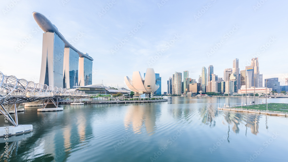 Fototapeta premium Singapore, 30 Oct 2018: a sunrise skyline view of the Marina Bay with the Helix Bridge, the Marina Bay Sands hotel and the Central Business District in Singapore.