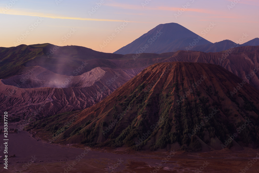 Mount Bromo volcano crater erupts in the caldera, behind Gunung Batok, with Gunung Semeru in the background, Java, Indonesia.